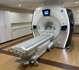 A Discovery 3.0T MRI in an imaging room with a set of cabinets to the left.