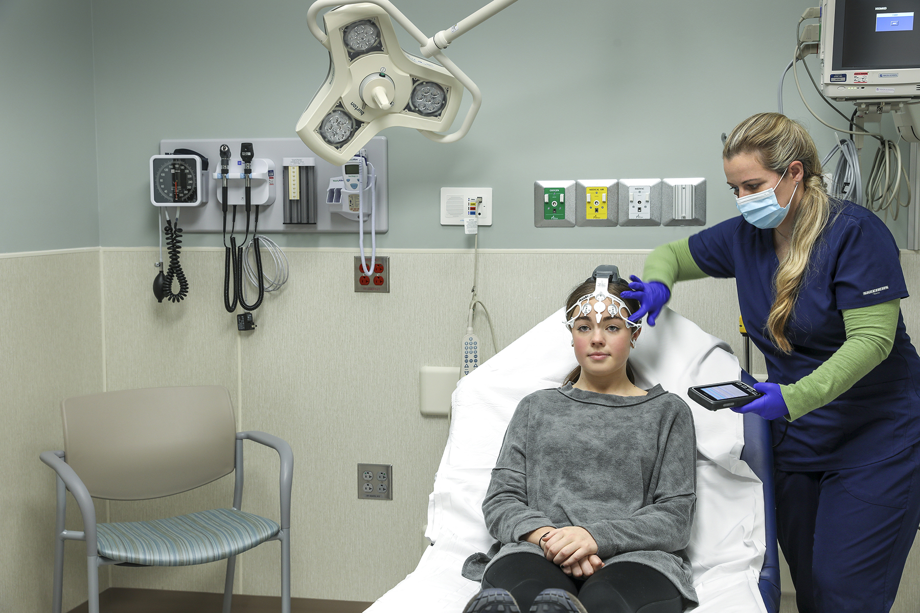 A nurse implementing a brainscope scanning device on a patient in the emergency room.